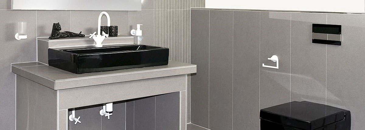 Graue Fliesen in Kombination mit schwarzen Sanitärobjekten und weißen Armaturen.